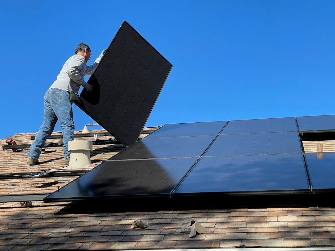 Home Worker installing solar panels on a roof