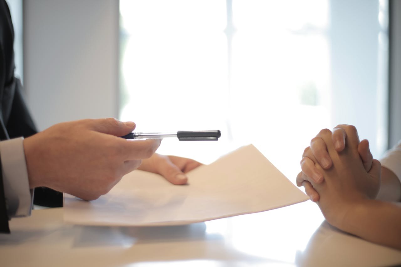 Offerings Close-up of a contract signing with hands over documents. Professional business interaction.